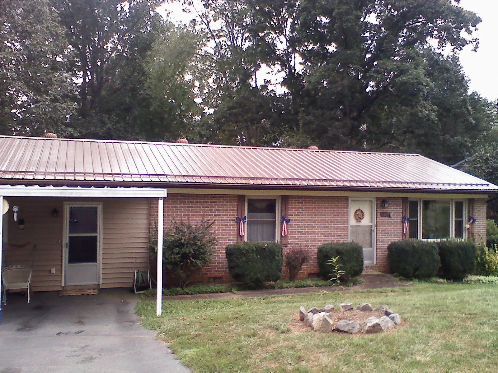 Bronze metal roof and carport on a brick ranch home — Roof Repair work by our crew in Gibsonton