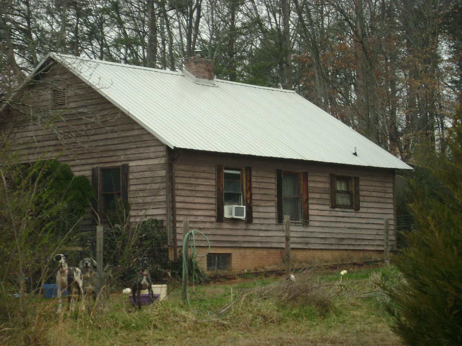 White metal roof on an old wood sided farmhouse, from a Metal Roof Installation job in Gibsonton